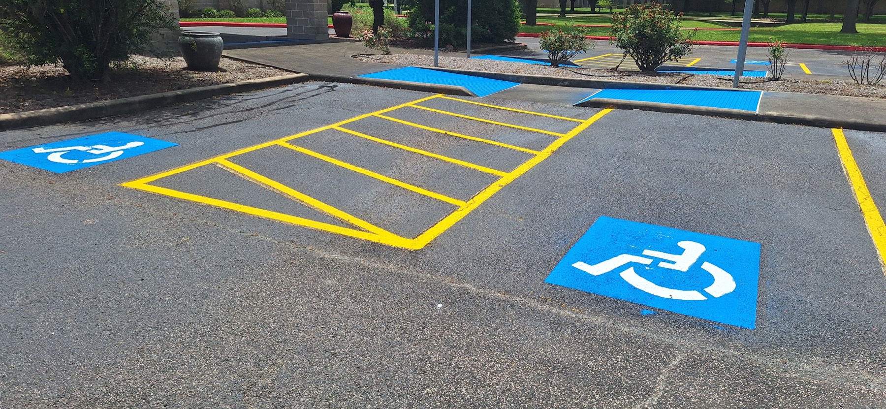 Fresh blue accessible parking symbols and yellow access-aisle markings