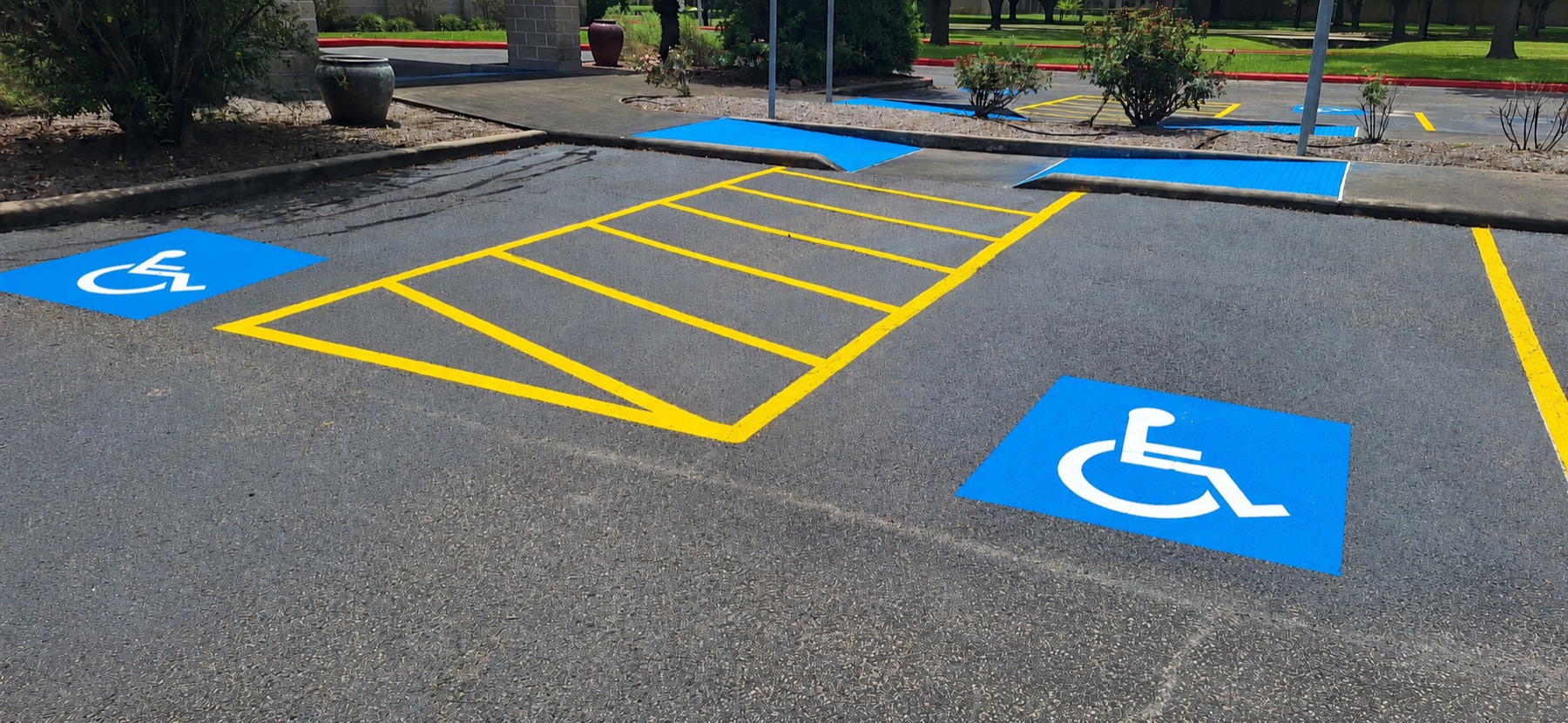 Completed accessible spaces with blue symbols and yellow access aisle