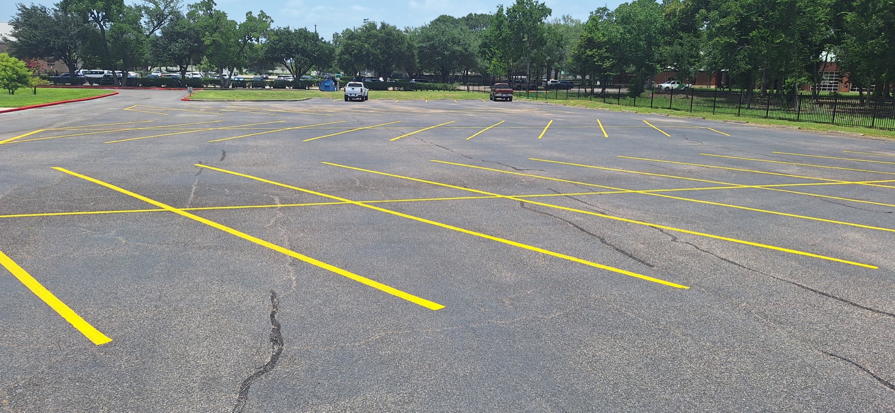 Fresh yellow parking lot lines across a commercial property near Houston