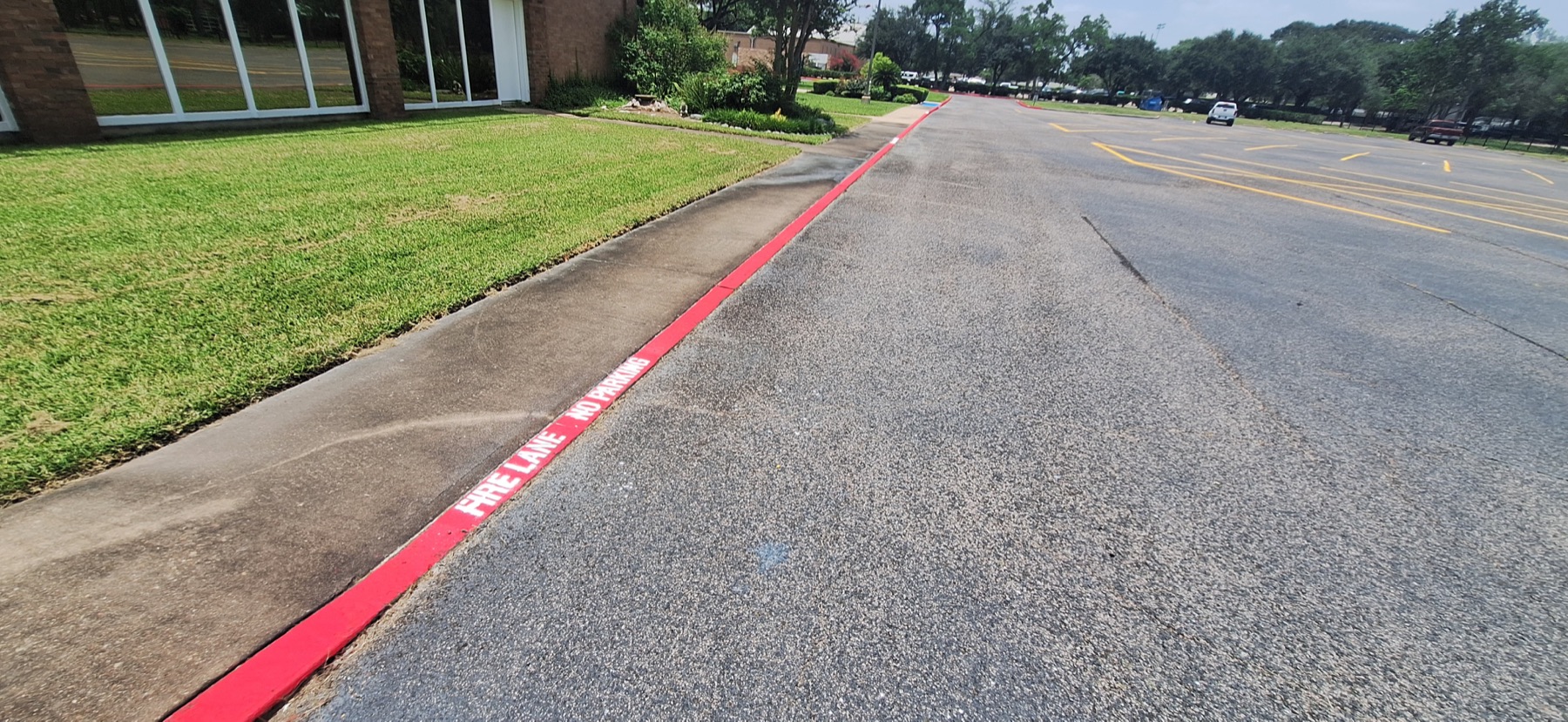 Fresh red fire lane curb with white fire lane no parking lettering